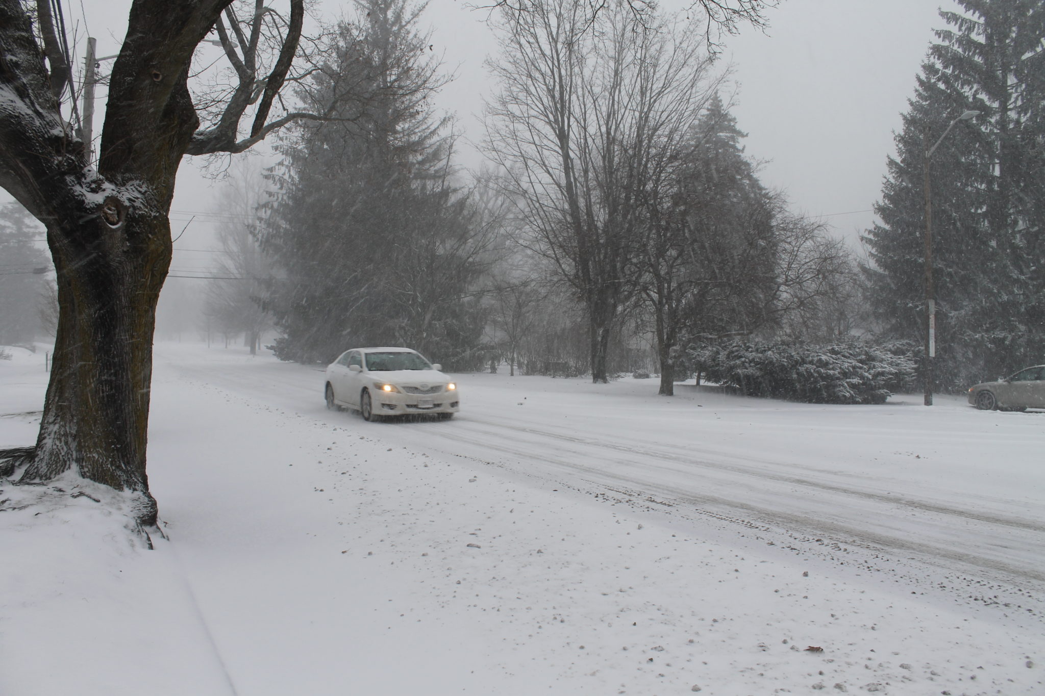 A CAR HEADS TOWARDS Providence on Blackstone Boulevard as snow starts to accumulate in Rhode Island. / PBN FILE PHOTO/MARY MACDONALD