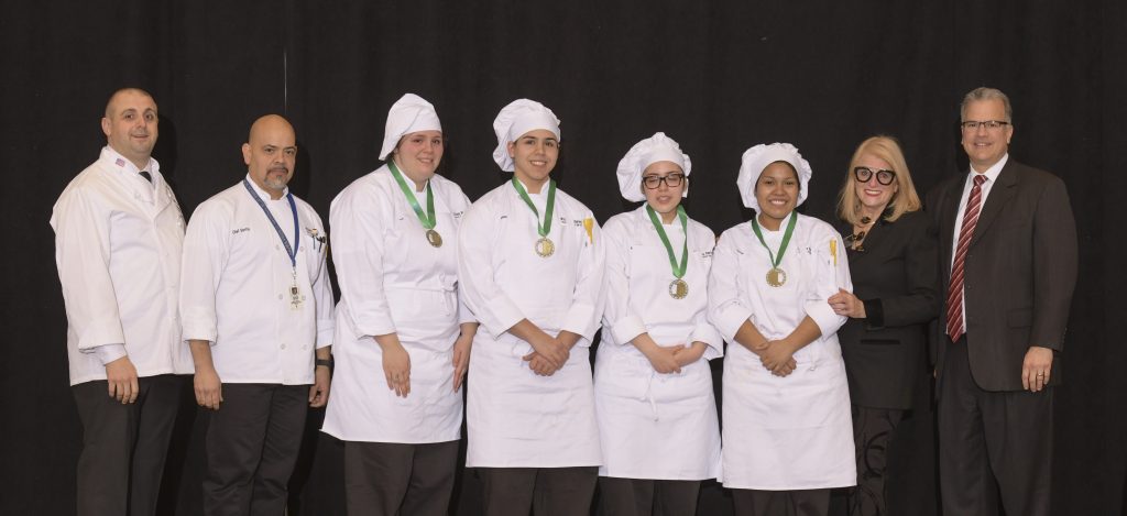 WILLIAM M. DAVIES, JR. Career & Technical High School's team won the Culinary Arts portion of the 7th Annual Rhode Island Prostart High School Culinary & Management Competition. From left to right: Chef Ray McCue, Johnson & Wales University; Instructor Chef Santos Nieves, William M. Davies, Jr. Career & Technical Center; students Victoria Carrion, Fabian Vargas, Alexia Guzman, and Britney Fernandez; Dale Venturini, President & CEO, RI Hospitality Association; Rhode Island Speaker of the House Nicholas Mattiello. / COURTESY RHODE ISLAND HOSPITALITY EDUCATION FOUNDATION