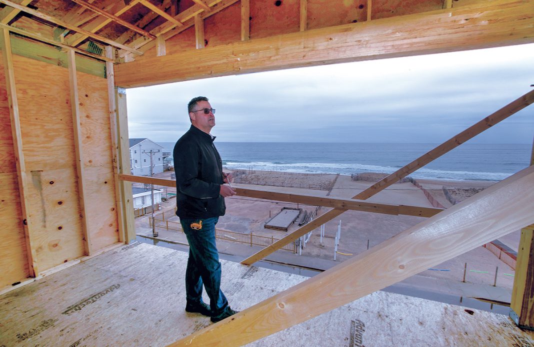 TOP VIEW: John Ballone, owner of The Hotel Maria, on the highest level of the structure under construction alongside Misquamicut Beach in Westerly designed to avoid the effects of ocean flooding by being elevated well above sea level. The Atlantic Ocean can be seen in the background. / PBN PHOTO/ BRIAN MCDONALD