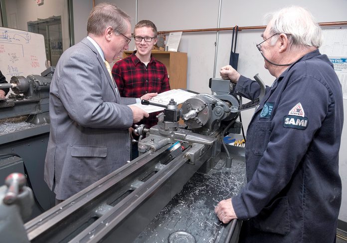 IN THE CLASSROOM: Steven H. Kitchin, left, New England Institute of Technology vice president for corporate education and training, speaks with Kaleb Buffum, a student in the Shipbuilding Advanced Manufacturing Institute program, while instructor Wayne Farmer looks on at the facility on Post Road in Warwick. / PBN PHOTO/MICHAEL SALERNO