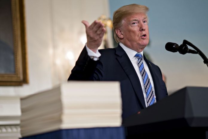 PRESIDENT DONALD TRUMP speaks next to the $1.3 trillion spending bill H.R. 1625 in the Diplomatic Room of the White House in Washington, D.C., on Friday. / BLOOMBERG PHOTO/ANDREW HARRER