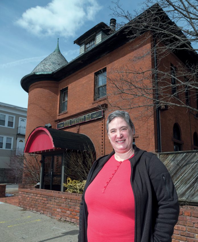ENDANGERED PROPERTY: Barbara Zdravesky, president of the Preservation Society of Pawtucket, in front of Hose Company No. 6 on Central Avenue in Pawtucket. The society says the commercial building is being threatened with demolition. / PBN PHOTO/MICHAEL SALERNO