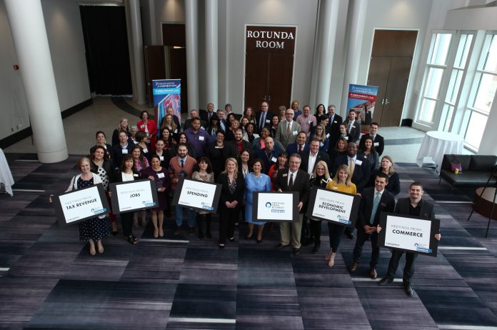 HOSPITALITY PROFESSIONALS AND RHODE ISLANDERS who helped to bring meetings and sporting event business to the Ocean State celebrate Global Meetings Industry Day at the Providence Warwick Convention and Visitors Bureau Ambassador award ceremony. PWCVB President and CEO Martha Sheridan (in black) and R.I. Secretary of State Nellie Gorbea (in blue) are in the center. / COURTESY PWCVB HOSPITALITY PROFESSIONALS AND RHODE ISLANDERS who helped to bring meetings and sporting event business to the Ocean State celebrate Global Meetings Industry Day at the Providence Warwick Convention and Visitors Bureau Ambassador award ceremony. PWCVB President and CEO Martha Sheridan (in black) and R.I. Secretary of State Nellie Gorbea (in blue) are in the center of the front row. / COURTESY PWCVB