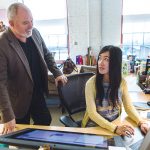 EVOLVING BUSINESS: Wayne R. Blatchley, owner of Pawtucket-based Fuzion Design, speaks with Esther Tseng, associate creative director. The company was launched 10 years ago and focuses on brand-driven design, digital services and packaging. / PBN PHOTO/RUPERT WHITELEY