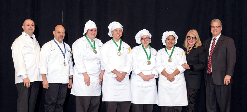 CULINARY COMPETITORS: A team of chef and food-service students from the William M. Davies, Jr. Career and Technical Center in Lincoln was one of two Rhode Island teams to compete in the finals of the National ProStart Invitational, a nationwide chef and restaurateur competition, held at the R.I. Convention Center in Providence in late April. From left, Ray McCue, chef instructor at Johnson & Wales University; Santos Nieves, chef instructor at Davies; students Victoria Carron, Fabian Vargas, Alexia Guzman and Britney Fernandez; Dale Veturini, president and CEO, Rhode Island Hospitality Association; and House Speaker Nicholas A. Mattiello. / COURTESY RHODE ISLAND HOSPITALITY EDUCATION FOUNDATION