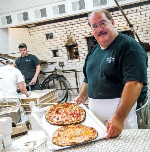 PIZZA PREP: Gary Bimonte, grandson of Frank Pepe and co-owner of Frank Pepe Pizzeria Napoletana, prepares pizza at the restaurant’s original location in New Haven, Conn. The latest Frank Pepe location and the first in Rhode Island recently opened in Warwick. / COURTESY FRANK PEPE PIZZERIA NAPOLETANA