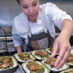 FULLY PREPARED: Natasha Daniels, sous chef for PVD Dinner Share, a meal-prep service that provides fully cooked and prepared meals each week, in the kitchen preparing jerk chicken with braised greens on coconut rice for customer pickups. / PBN PHOTO/MICHAEL SALERNO