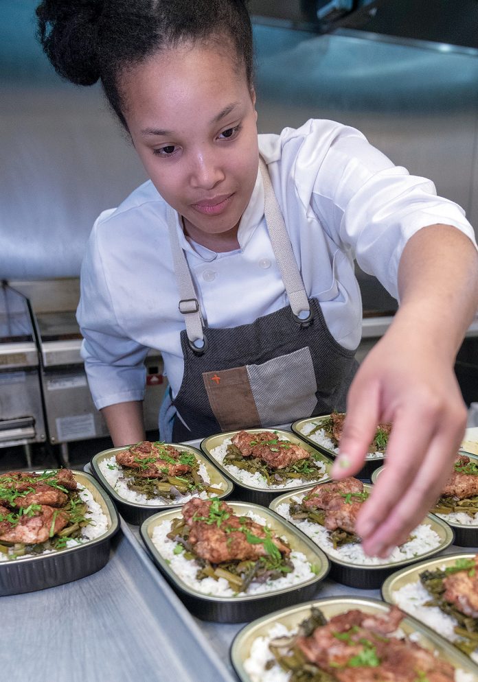 FULLY PREPARED: Natasha Daniels, sous chef for PVD Dinner Share, a meal-prep service that provides fully cooked and prepared meals each week, in the kitchen preparing jerk chicken with braised greens on coconut rice for customer pickups. / PBN PHOTO/MICHAEL SALERNO
