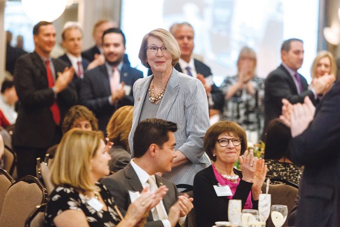 AT THE TOP OF HER GAME: BankNewport President and CEO Sandra J. Pattie heads to the podium at the 2018 PBN Business Women Awards luncheon to accept her Career Achievement award.  / PBN PHOTO/ RUPERT WHITELEY