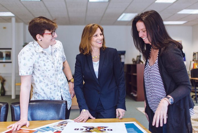 NO STANDING STILL: From left, Cassie Dana, event coordinator at DK Communications; owner Dyana Koelsch; and Jane D’Arcy, the director of marketing, review a project in the PR firm’s Providence office. / PBN PHOTO/RUPERT WHITELEY
