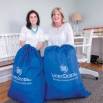 HEAVY LOAD: Rosa Ciunci, left, and Maureen Pagliaro, co-founders of LinenDrops.com, provide linen services for vacation and short-term rental properties throughout the region.  / PBN PHOTO/MICHAEL SALERNO