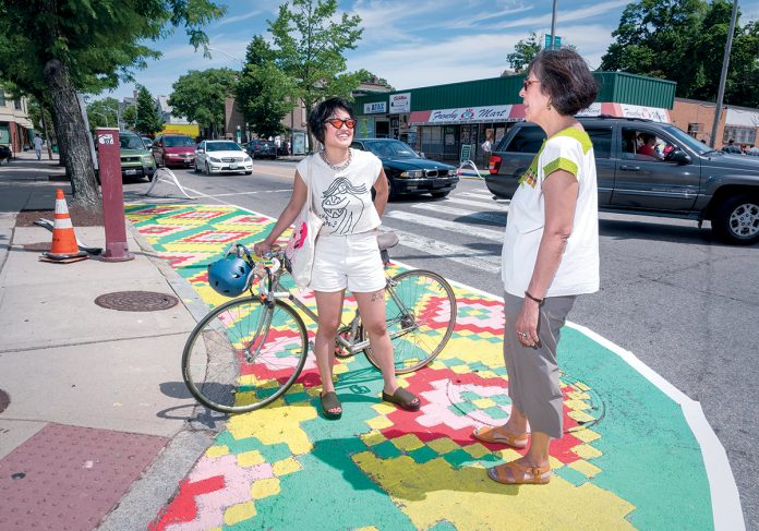 0706cover2 A RICHER TOURISM EXPERIENCE: The Providence Warwick Convention & Visitors Bureau has created a series of 15 neighborhood maps to direct visitors to Providence districts that have distinct characteristics that it believes will reward tourists with enjoyable experiences. Marta Martinez, right, executive director of RI Latino Arts and host of the Broad Street neighborhood walking tour, and Dana Heng, artist who painted a mural along and off of Broad Street through a project sponsored by the city. / PBN FILE PHOTO/MICHAEL SALERNO