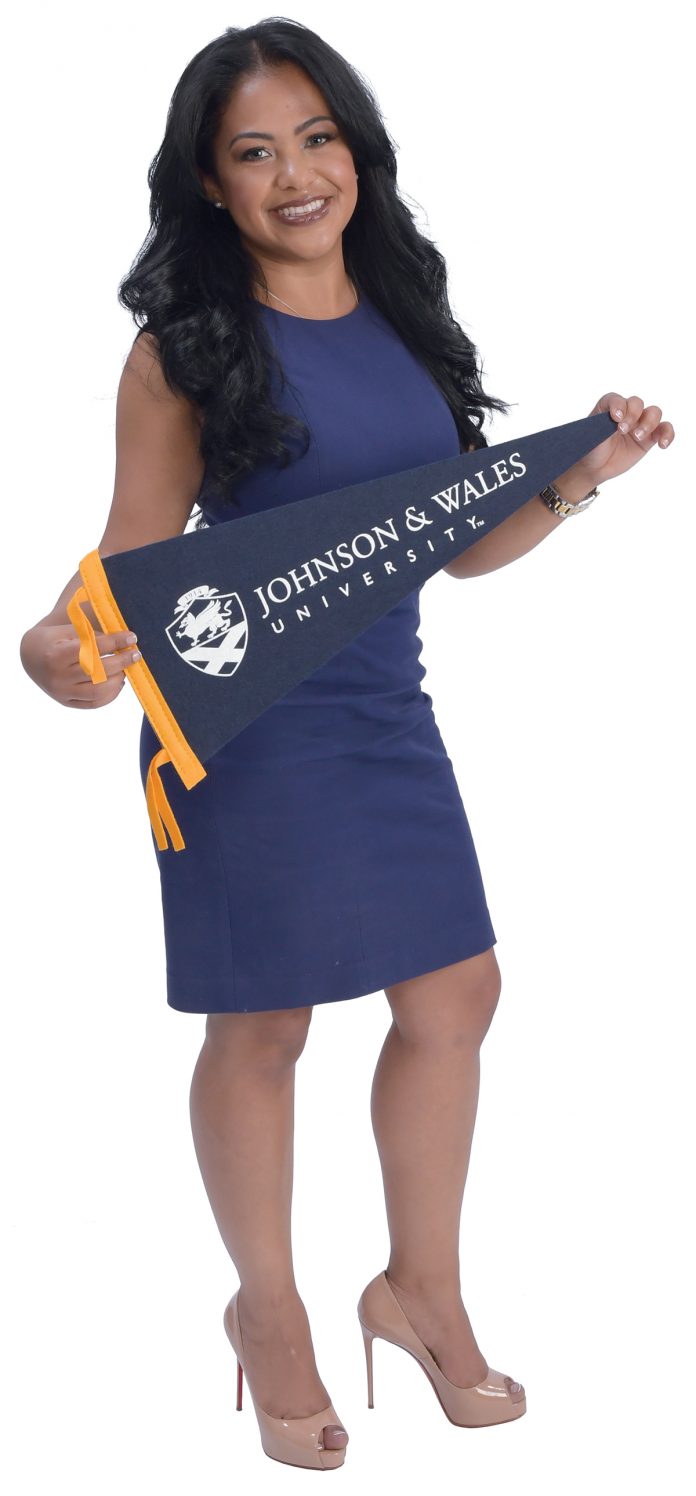 the prop: Rafaelina Gomez holds a Johnson & Wales University banner to signify her introduction to Massachusetts and Rhode Island. The college is how she met friends and got her first job. / PBN PHOTO/MIKE SKORSKI