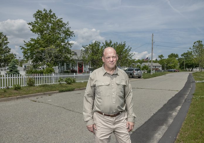 FLOOD-PRONE: Grover Fugate, executive director of the R.I. Coastal Resources Management Council, stands in front of properties on Strand Avenue in an at-risk area for flooding near the Oakland Beach neighborhood in Warwick.  / PBN PHOTO/MICHAEL SALERNO
