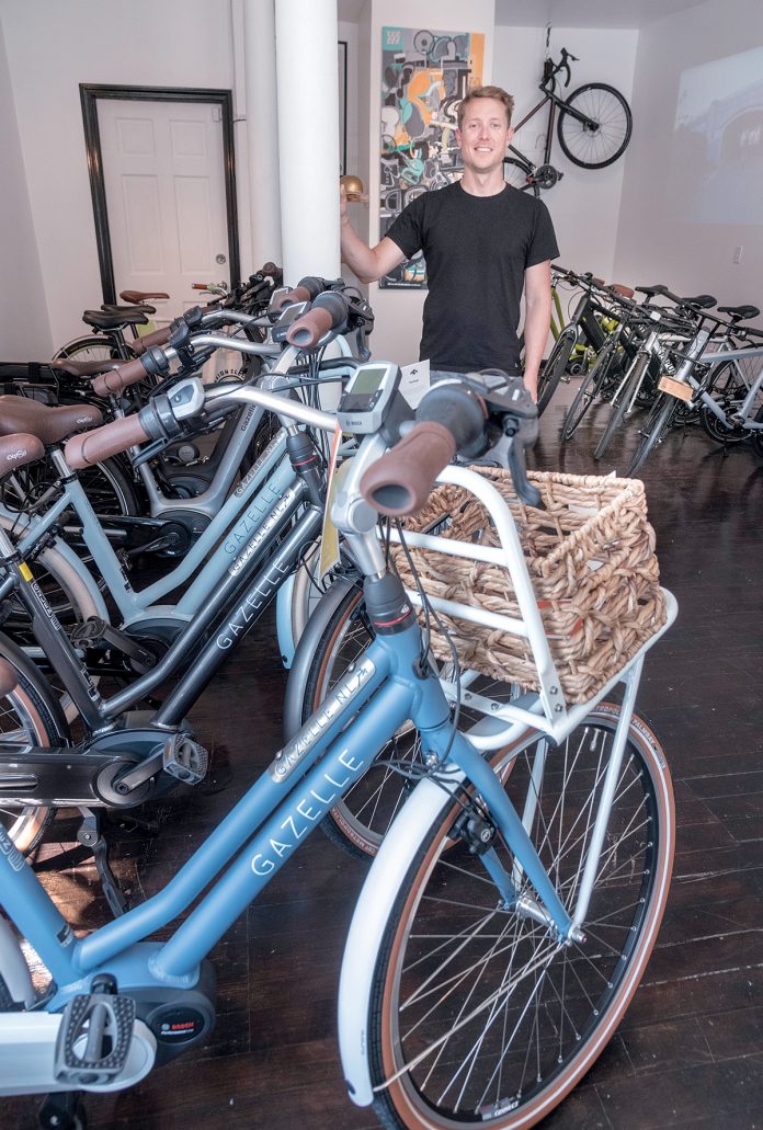 ELECTRIC BIKES: Tyler Justin is the owner of Providence-based Mission Electric, a shop selling and maintaining electric bicycles. E-bikes can be used on the street or bike trails but can be switched into electric mode on uphill climbs.  / PBN PHOTO/MICHAEL SALERNO