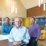 STEADY RESULTS: Edward W. Burman Jr., center, with sons Edward "Tripp" Burman III, left, and Andrew in the University of Rhode Island’s new welcome center conference room, designed by E.W. Burman Inc.  / PBN PHOTO/DAVE HANSEN