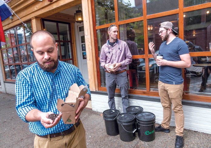 WASTE NOT: Earthly co-founders Frank Mastrobuono, left, and Mike Kowalczyk, center, pick up food waste at Empire Tea & Coffee in Newport. Earthly produces worm castings, a natural fertilizer. Mastrobuono shows the finished potting mix, as Kowalczyk and Empire manager Josh Unorski talk.   / PBN PHOTO/MICHAEL SALERNO