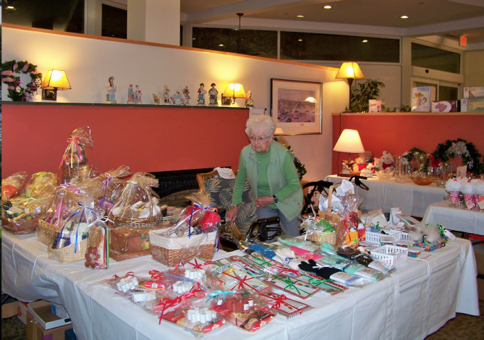 A WOMAN OBSERVES items for sale during last year's Harvest Time Fair, hosted by United Methodist Elder Care, which has since become Aldersbridge Communities. This year's fair will be held Nov. 9-10 at two East Providence locations, Winslow Gardens and Linn Health & Rehabilitation. / COURTESY ALDERSBRIDGE COMMUNITIES