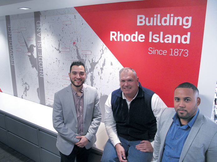RECOGNIZING ­OPPORTUNITY: ­Gilbane Building Co. Vice President and Rhode Island business unit leader John Sinnott is flanked by Christopher L. Calderon, left, and Edwin A. Montas at the company’s Providence headquarters, where Sinnott oversees much of the local recruitment efforts to better match the company’s workforce with the local community.   / PBN PHOTO/ MARK S. MURPHY