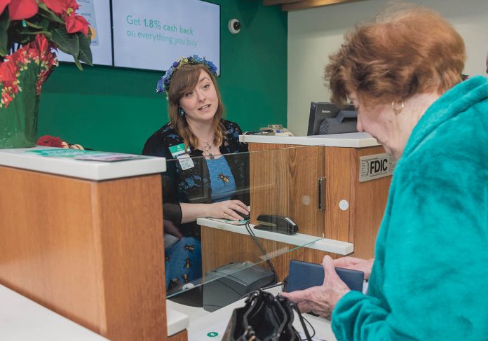 ASSISTING CUSTOMERS: Bank teller Kayla Beauvais, left, helps Jacqueline Daigneault of Cumberland at the Citizens Bank branch in town at 2000 Mendon Road. / PBN PHOTO/MICHAEL SALERNO