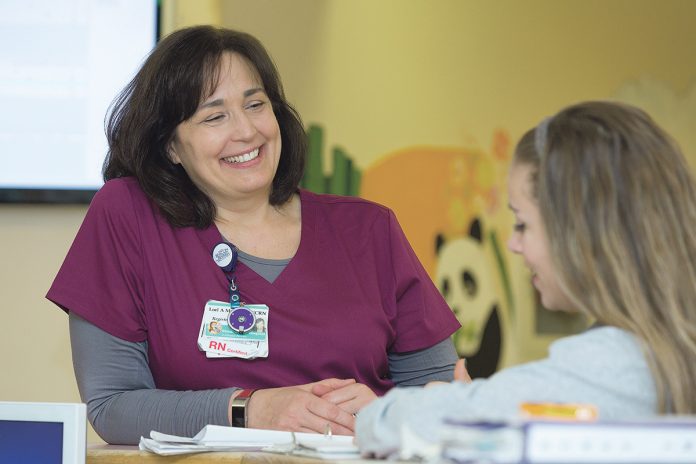 GROWING SECTOR: Lori Mayer, left, a veteran pediatric intensive care nurse at Hasbro Children’s Hospital in Providence, speaks with Abigail King, another PICU nurse. The state is projected to add 860 registered nurse jobs by 2026, according to the R.I. Department of Labor and Training.  / COURTESY LIFESPAN CORP.