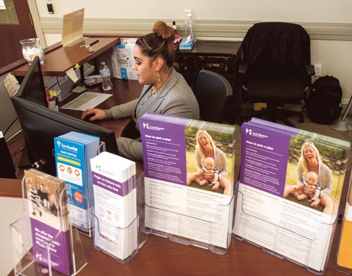 INCREASED ENROLLMENT: Aaliyah Perez is a customer service representative at HealthSource RI’s Walk-in Center in East Providence. The state’s health exchange had enrolled 31,771 people for health care insurance as of Dec. 10, 11 percent higher than on the same date in 2017.  / PBN FILE PHOTO/MICHAEL SALERNO