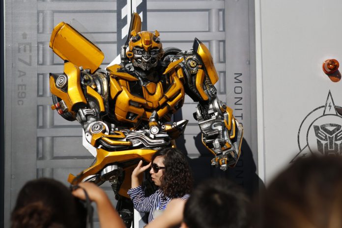 VISITORS POSE FOR PHOTOS with the Bumblebee character at the Universal Studios Hollywood theme park in California. / BLOOMBERG NEWS PHOTO/PATRICK T. FALLON