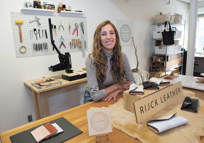 CREATIVE MIND: Alison Van Hemelrijck, owner of Rijck Leather, in her studio at Shady Lea Mill in North Kingstown. Van Hemelrijck previously worked in fashion design in California before switching gears to become a leather-goods manufacturer. / PBN PHOTO/KATE WHITNEY LUCEY CREATIVE MIND: Alison Van Hemelrijck, owner of Rijck Leather, in her studio at Shady Lea Mill in North Kingstown. Van Hemelrijck previously worked in fashion design in California before switching gears to become a leather-goods manufacturer. / PBN PHOTO/KATE WHITNEY LUCEY
