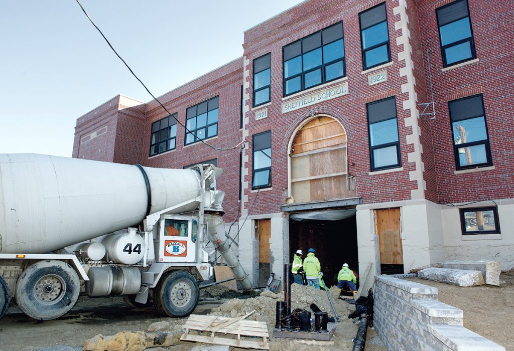 POURING CONCRETE: Construction workers pour concrete in the main entrance of the former Sheffield School building on Broadway in Newport. The former elementary school is being renovated to become the Innovate Newport business incubator.
/ PBN PHOTO/KATE WHITNEY LUCEY