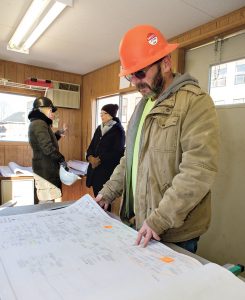BLUEPRINTS: Tom Jackman, a field superintendent from Pezzuco Construction, general contractor of the former Sheffield School renovation into the Innovate Newport business incubator, looks over blueprints in a trailer at the construction site.
/ PBN PHOTO/KATE WHITNEY LUCEY