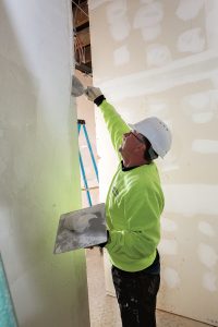 SHEFFIELD RENOVATION: Mike Plouffe of Pezzuco Construction, general contractor for the renovation of the former Sheffield School on Broadway in Newport to become the Innovate Newport business incubator, applies fast-drying compound to one of the walls of the building.
/ PBN PHOTO/KATE WHITNEY LUCEY