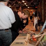 ATTENDEES MAKE THEIR bids on sports memorabilia during the Ocean State Waves' Black Tie & Blue Jeans fundraiser in 2016. This year's fundraiser will take place on Feb. 15 at The Towers in Narragansett. / COURTESY OCEAN STATE WAVES