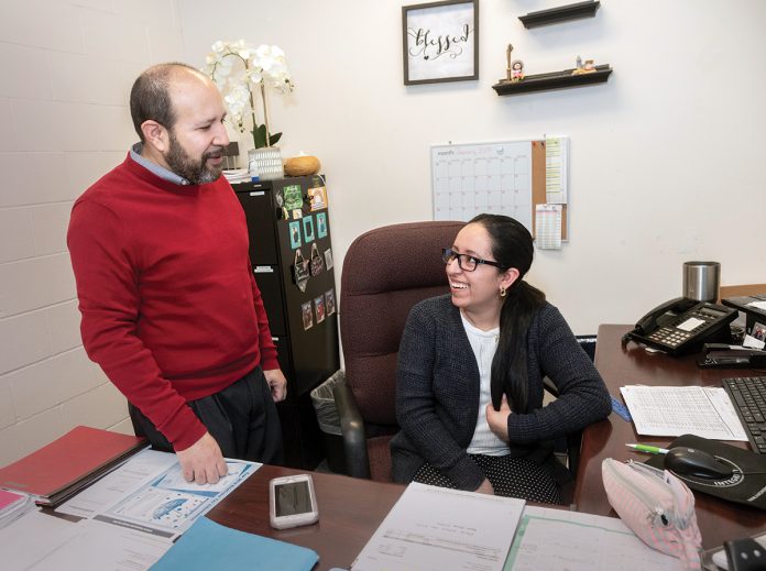 HIGHER PRIORITIES: Mario Bueno, executive director of Progreso Latino, a nonprofit that provides comprehensive social services to Latin Americans in Rhode Island, speaks with Johanna Tones, bookkeeper. Bueno said the 2020 census is not as high a priority for immigrants as other, more-pressing concerns, such as working and housing.  / PBN PHOTO/MICHAEL SALERNO