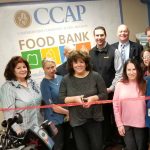 COMPREHENSIVE COMMUNITY ACTION Program staffers, Rotary Club of Cranston members and a representative of Shaw's Supermarket gather Tuesday to cut the ribbon on CCAP's newly expanded food bank at the nonprofit's office in Cranston. / COURTESY COMPREHENSIVE COMMUNITY ACTION PROGRAM