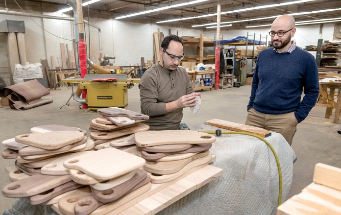 FILLING A NEED: Joshua Ellison, right, founder of Edge and End, with employee Jason Harritos, oversees an enterprise that helps people with developmental disabilities to have work experiences and hopefully employment through woodworking.  / PBN PHOTO/MICHAEL SALERNO