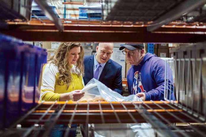 SHIP IT: Supply Chain Manager Daphne Johnstad and Supply Chain Director David Seaback, center, check in with Shipping Manager Peter Reynolds at Amgen Rhode Island’s West Greenwich facility.  / PBN PHOTO/RUPERT WHITELEY