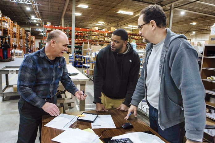 MINDING THE STORAGE: Steve Lorello, left, account manager, discusses logistics with warehouse associate Donald Roderick, center, and Gordon Fox, team leader, at Dean Warehouse Services.  / PBN PHOTO/RUPERT WHITELEY