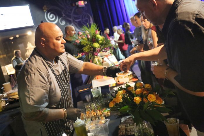 ATTENDEES SAMPLE FOOD items during last year’s inaugural Global Eats at Fete Music Hall in Providence. This year’s Global Eats event, hosted by Dorcas International Institute of Rhode Island, will be held on March 28 at Rhodes on the Pawtuxet in Cranston. / COURTESY DORCAS INTERNATIONAL INSTITUTE OF RHODE ISLAND