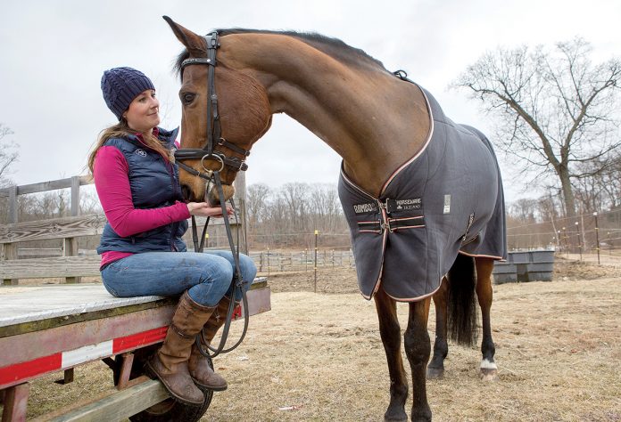 HORSE ENTHUSIAST: Kaitlyn Naughton, an equine insurance specialist at Naughton Insurance in East Providence, visits her horse, Baron, at Stony Creek Farm in Swansea. She said most equine insurance policyholders are middle-class people who are horse enthusiasts and recreational riders.  / PBN PHOTO/ KATE WHITNEY LUCEY