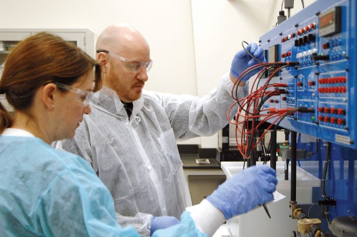 TEACHING TOOL: Megan Cortesi and Jeremy Demers, students in the process technician program at the Westerly Education Center, use a teaching tool that mimics industrial systems in the handling of liquids.  / PBN PHOTO/ BRIAN MCDONALD