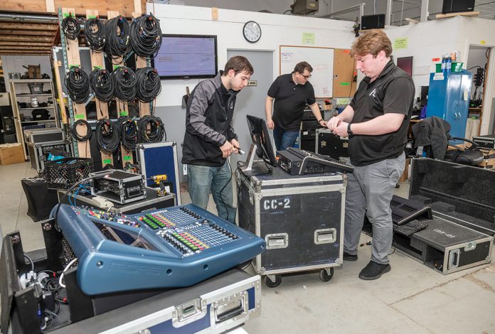 GEAR PREP: Advanced Production and Design in Warwick provides audio and visual equipment and other event-production services. From left, Evan Perry, chief operating officer; Patrick Boutwell, production and warehouse technician; and Adam Ramsey, CEO, prep gear for a job.  / PBN PHOTO/MICHAEL SALERNO