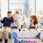 AFTER GOING ON-AIR with his mother to share his story as a Hasbro Children’s Hospital, 7-year-old Kai Vitolo joined volunteers at the phone bank to take calls from donors during the hospital's annual radiothon last Thursday. / COURTESY HASBRO CHILDREN'S HOSPITAL.
