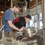 EXPANDED OPERATION: Newport Vineyards co-owner John Nunes, right, works on a batch of Vineyard Pilsner with Kevin Beachem of Taproot Brewing. The brewery was added to the vineyard as part of a $4 million renovation and expansion.  / PBN PHOTO/KATE WHITNEY LUCEY