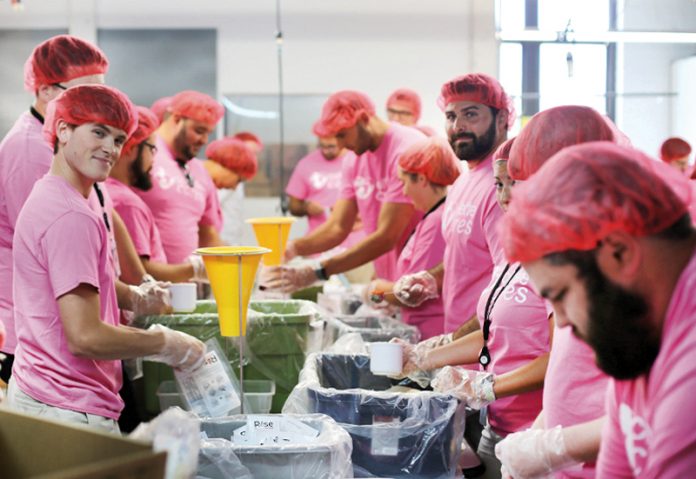 DOING THEIR PART: Collette employees participate in a meal-packaging event in partnership with Rise Against Hunger last July.  / COURTESY COLLETTE