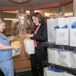 DELIVERING SMILES: Kerri Baker, left, child-life specialist at Hasbro Children’s Hospital, receives gift bags for sick children, from Amy Antone of the Cuddles of Hope Foundation.  / PBN PHOTO/MICHAEL SALERNO