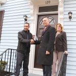 RENOVATED HOME: Homeowner Carlos Reyes, left, is pictured with Providence Mayor Jorge O. Elorza and Smith Hill Community Development Corp. Executive Director Jean Lamb in front of his home at 120 Camden Ave. during ceremonies to celebrate homeowners moving into houses renovated under the city’s EveryHome program.  / COURTESY CITY OF PROVIDENCE