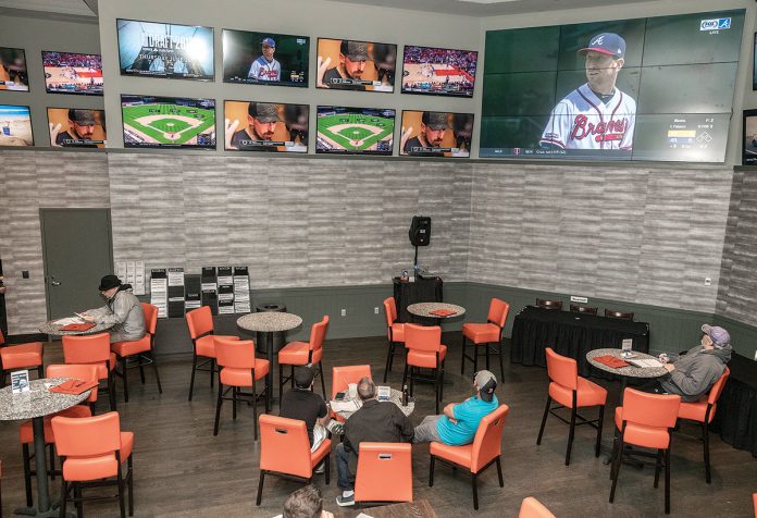 SPORTSBOOK: Guests relax in a lounge at the sportsbook at the Twin River Casino Hotel in Lincoln. The casino’s sports-betting venue opened in late November and, together with the sportsbook at Tiverton Casino Hotel, which opened a week later, generated nearly $624,000 through March.    / PBN PHOTO/MICHAEL SALERNO