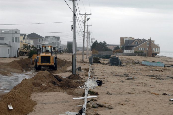 OVER 25,000 single-family homes are considered at-risk to be impacted by storm surge in the event of a Category 4 hurricane in Rhode Island. Above, a machine clears sand off Atlantic Avenue in Westerly after the remnants of Hurricane Sandy battered Rhode Island’s coast in 2012. / PBN FILE PHOTO/BRIAN MCDONALD