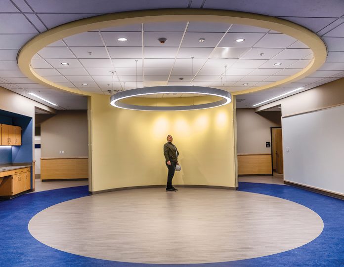 BREAKOUT SPACE: Barrington Middle School, now under construction, includes state-of-the-art classrooms and meeting spaces designed for collaborative learning. Brian Solywoda, a principal from architect Kaestle Boos Associates, stands in the breakout space with halo soffits.  / PBN PHOTO/MICHAEL SALERNO