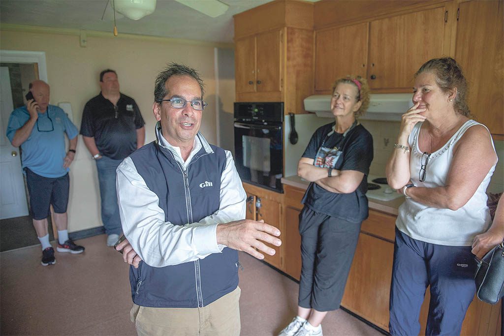 CORPORATE ASSETS: Auctioneer Sal Corio, left, talks with bidders prior to an auction at 365 Davisville Road in North Kingstown. Corio is the president of commercial liquidator SJ Corio Co. in Providence, which specializes in selling corporate assets, such as leftover equipment, on behalf of banks and creditors when businesses in Rhode Island go under. / PBN PHOTO/DAVE HANSEN